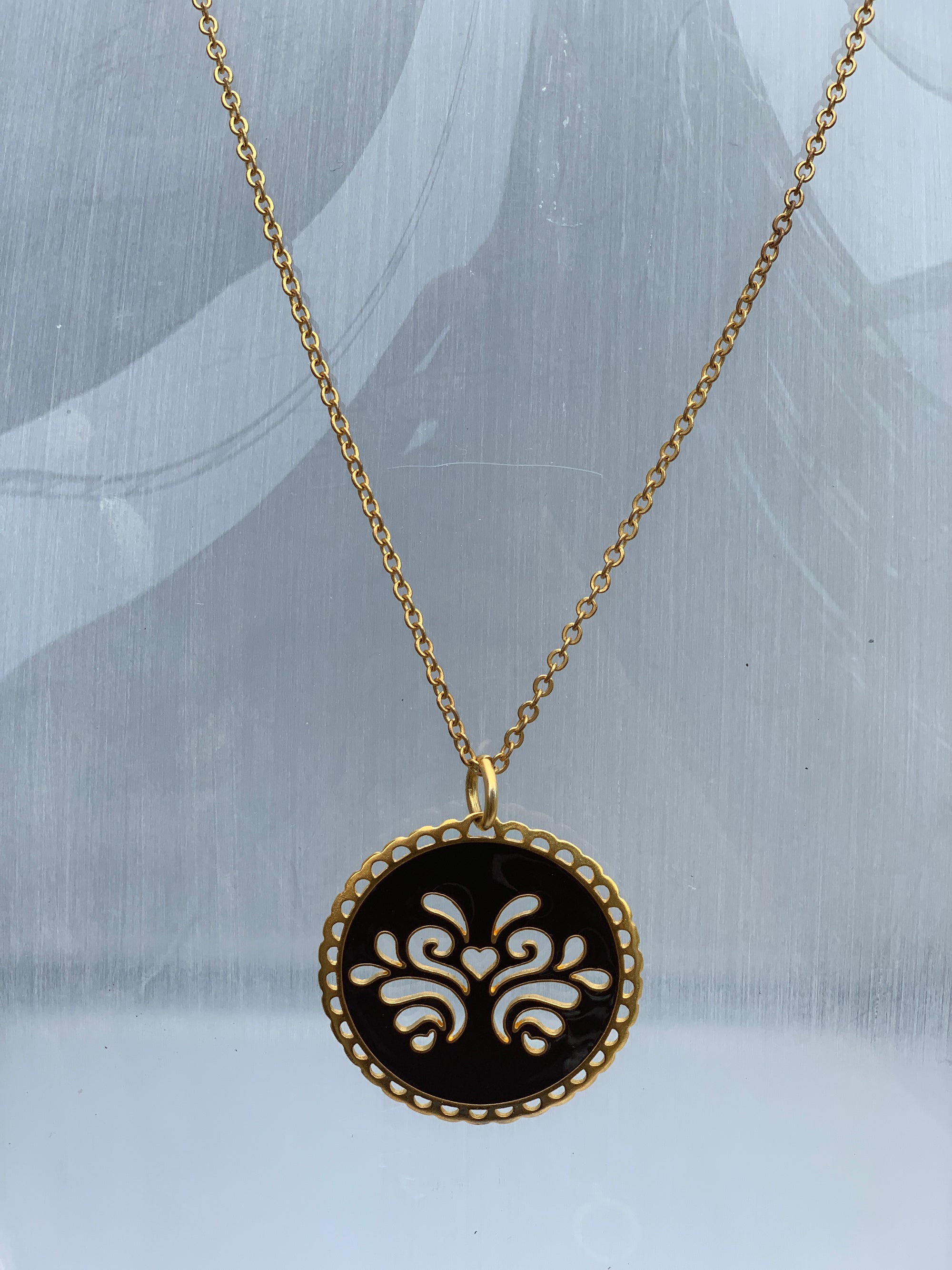 Circular reversible pendant on a chain